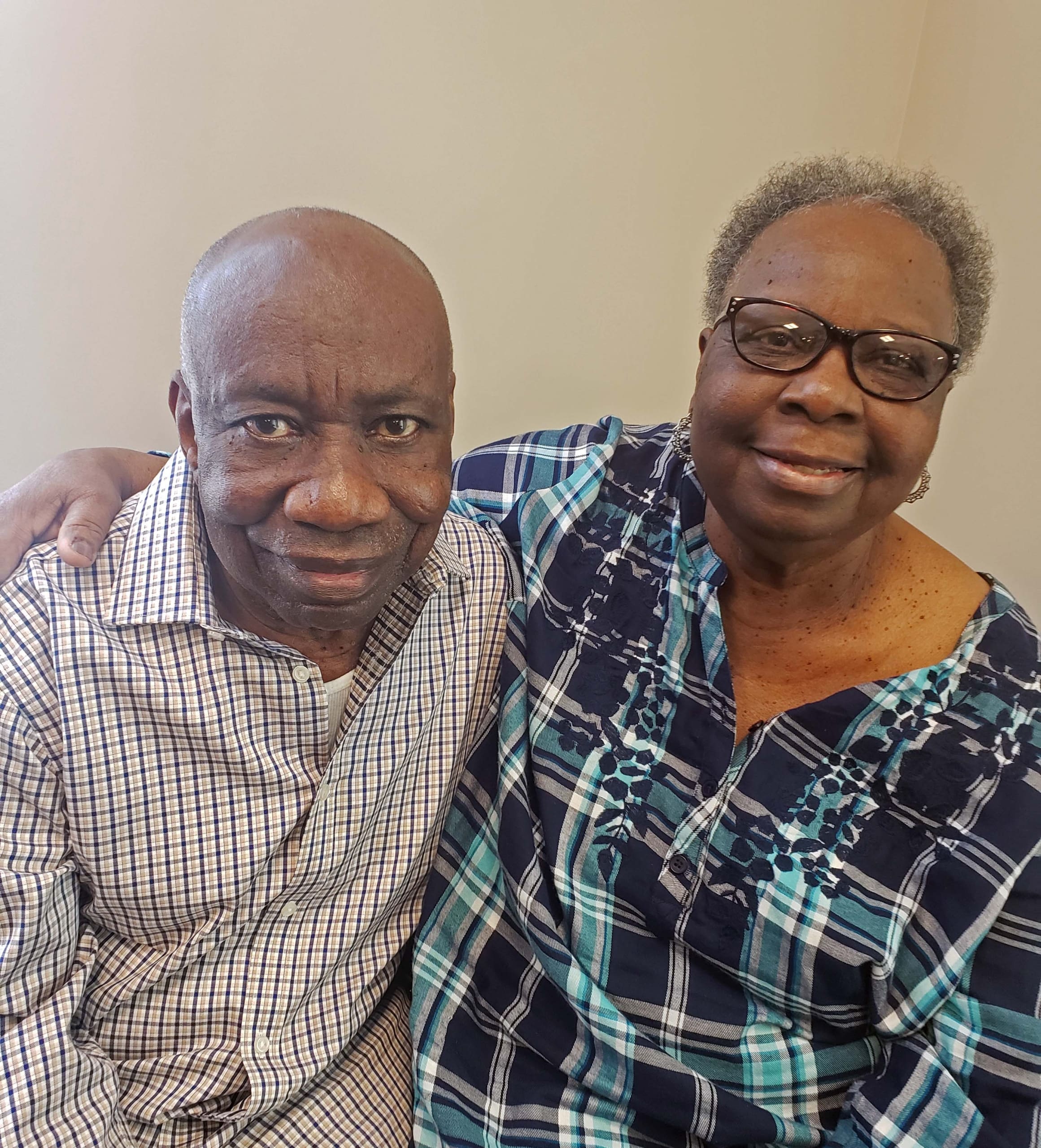 A husband and wife, smiling together for a photo.
