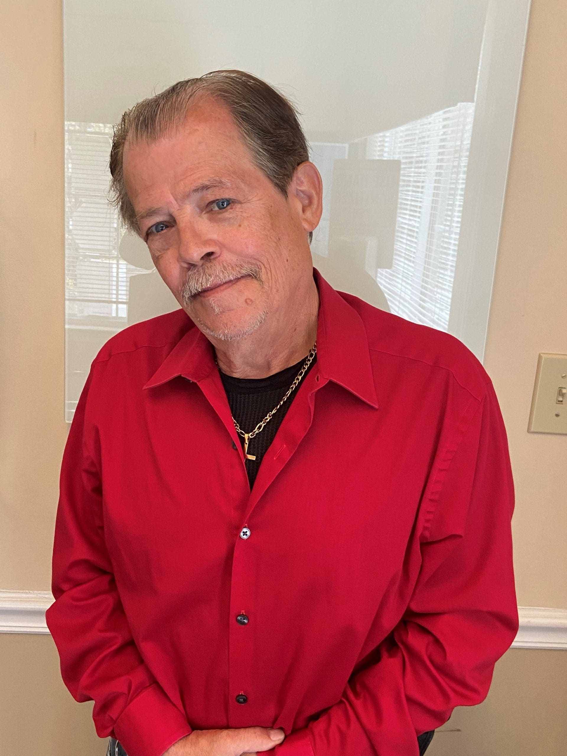 Man looking at the camera, wearing a red shirt