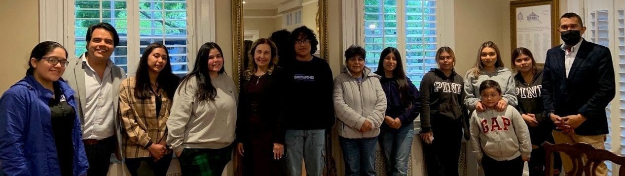13 people standing, smiling for the picture
