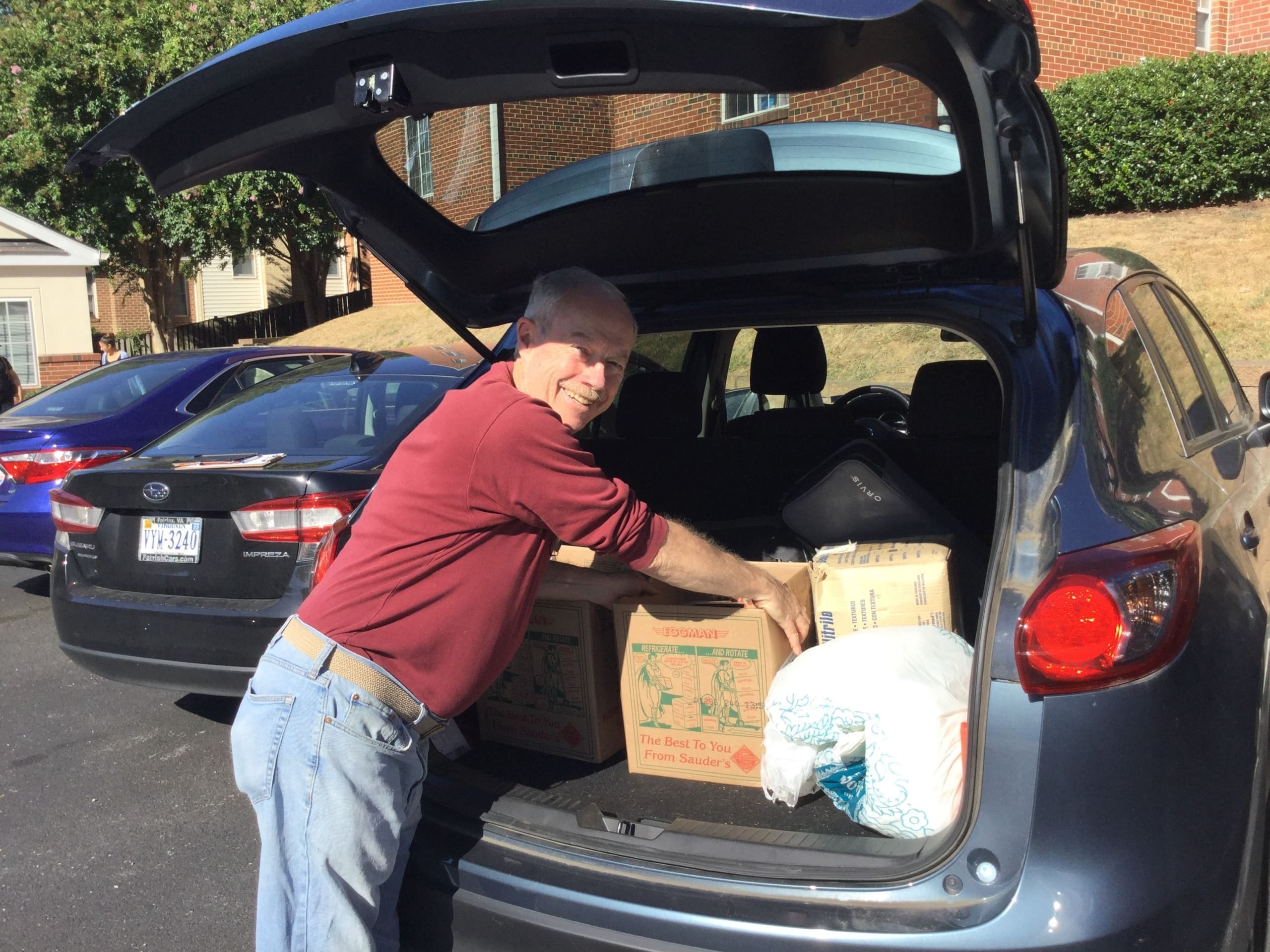 Tom transporting donation boxes in his car