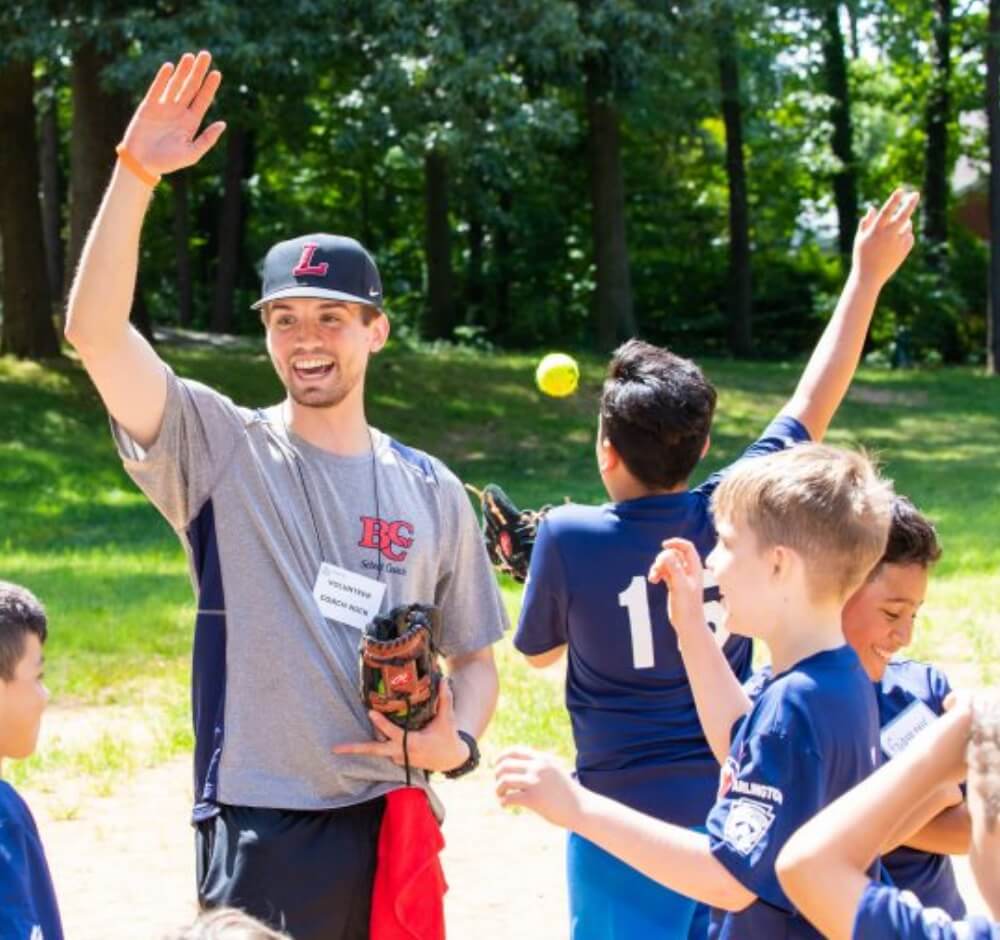 True-Ground-Group-Volunteers-Volunteering-FAQs@2x Coach leading kids in a baseball practice outdoors