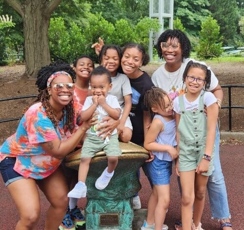 True-Ground-Volunteer-Groups-Become-a-Volunteer Group of smiling children and adults posing outdoors.